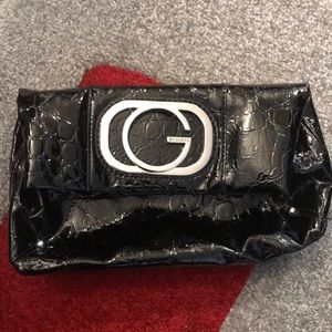 Black clutch with large silver “G” emblem